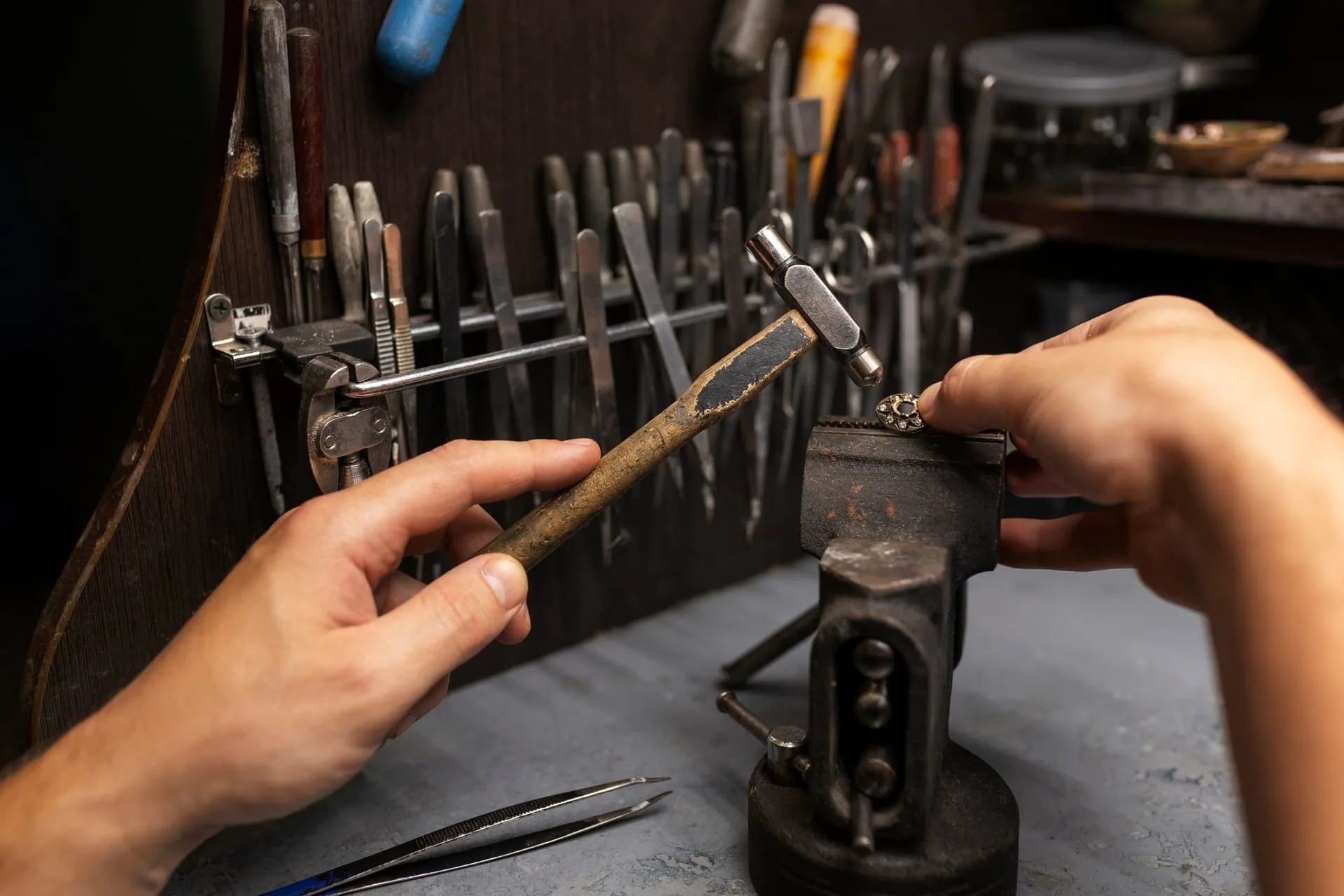 Handmade silver ring next to a workshop tool
